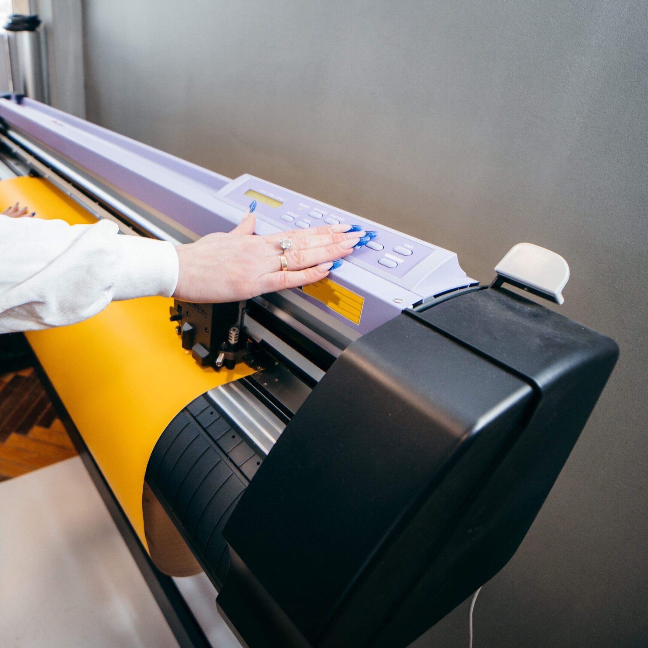 Person operating large printing machine.